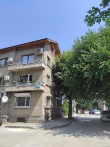 a building with a tree in front of it at Етаж от къща - Нощувки Ками in Pleven