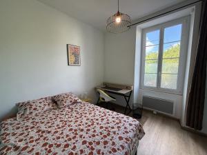 a bedroom with a bed and a window and a desk at Meublé paisible in Tonnerre