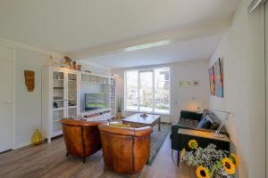 a living room with a couch and a table at Vakantiehuis Zeevogel - Julianadorp aan Zee in Julianadorp