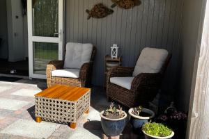 two chairs and a coffee table on a patio at Vakantiehuis Zeevogel - Julianadorp aan Zee in Julianadorp