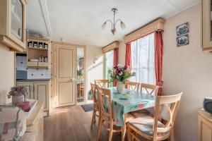 a kitchen and dining room with a table and chairs at Chalet Huffels P12 - Camping De Nollen Callantsoog in Callantsoog