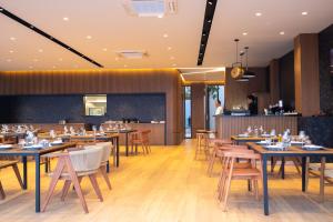 a restaurant with wooden tables and chairs and a counter at Aurum Hotel in Palasë