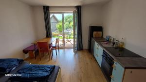 a room with a kitchen with a table and a counter top at Sunhill Apartamente in Karrösten