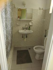 a bathroom with a sink and a toilet at PanTheo Studio's in Tyros