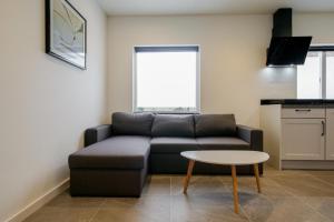 a living room with a couch and a table at Beachstudio - Centrum Callantsoog aan Zee in Callantsoog +43 photos