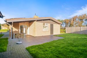 a small house with a patio in a yard at Vakantiehuis Beau - Julianadorp aan Zee in Julianadorp