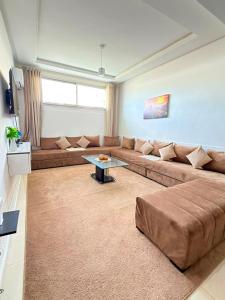 a living room with a large couch and a table at Sea et sun appartement in Tangier