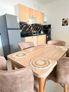 a kitchen with a wooden table with chairs and a refrigerator at Sea et sun appartement in Tangier +3 photos
