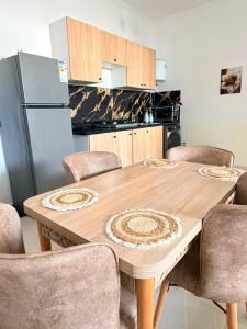 a kitchen with a wooden table with chairs and a refrigerator at Sea et sun appartement in Tangier