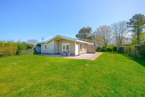 a small house with a lawn in front of it at Vakantiehuis Duynloper - Julianadorp aan Zee in Julianadorp +60 photos