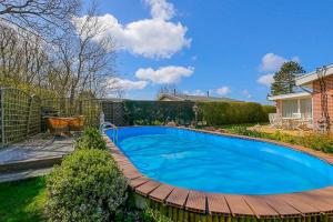 a swimming pool in a yard with a wooden deck at Vakantiehuis Springtij met privé zwembad - Julianadorp aan Zee in Julianadorp +56 photos
