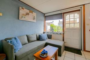 a living room with a couch and a table at Tiny House Petite - Callantsoog aan Zee in Callantsoog