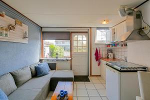 a living room with a couch and a kitchen at Tiny House Petite - Callantsoog aan Zee in Callantsoog +30 photos
