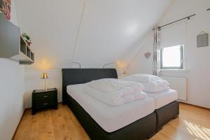 a bedroom with two beds with white sheets at Villa Schaut - Villapark De Buitenplaats Callantsoog aan Zee in Callantsoog