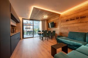 a living room with a couch and a table with chairs at Echo - Private Spa Apartments in Ponte di Legno