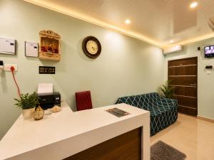 a waiting room with a counter and a clock on the wall at HOTEL VARANASI DV - Near Shree Kashi Vishwanath Temple in Varanasi