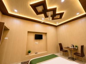 a room with a bed and a tv and a table at HOTEL VARANASI DV - Near Shree Kashi Vishwanath Temple in Varanasi