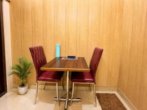 a table with two chairs and a blue vase on it at HOTEL VARANASI DV - Near Shree Kashi Vishwanath Temple in Varanasi