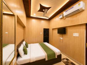 a bedroom with a bed and a tv in it at HOTEL VARANASI DV - Near Shree Kashi Vishwanath Temple in Varanasi +3 photos