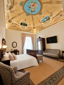 a bedroom with a ceiling with a painting on it at Palazzo Il Cavaliere B&B De Charme in Modica