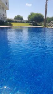 a large pool of blue water in front of a building at Sea et sun appartement in Tangier