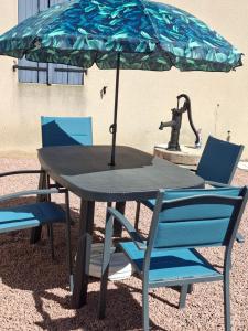 a table with two chairs and an umbrella at Gite du Canal in Gannay-sur-Loire