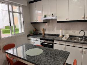 a kitchen with white cabinets and a counter top at Casa Pepe in Ourense