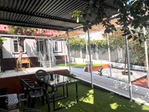 a patio with a table and chairs under a pergola at Casa Pepe in Ourense