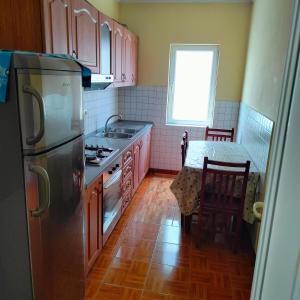 a kitchen with a stainless steel refrigerator and a table at Beach Guest House in Durrës