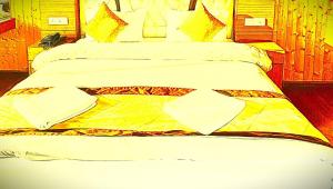 a bedroom with a bed with a yellow blanket at The Trisha Hotel in kolkata
