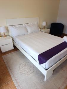 a bedroom with a large white bed and a chair at Casa Erica in Soyo +44 photos