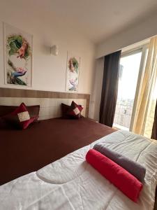 a bedroom with a large bed with a red pillow on it at Lord krisna place --Near Prem Mandir & ISKCON in Vrindāvan