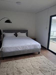 a bedroom with a bed and a large window at Villa Clair de Lagon in Blue Bay