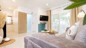 a living room with a couch and a tv at Lavoe Villas Samui in Nathon Bay