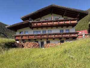 a house on top of a grassy hill at Gipfelblick Appartements in Umhausen