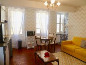 a living room with a yellow couch and a table at Aux Portes des Thermes in Lectoure