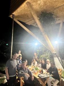 a group of people sitting around a wooden table at Tree House & Camping Goris in Goris +42 photos