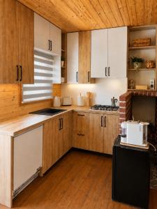 a kitchen with wooden cabinets and a white microwave at Lake View Glamping pod Radyní bez tekoucí vody s omezenou elektřinou in Hvížďalka