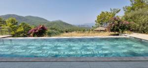 a swimming pool with mountains in the background at Iztuzu Sunset Villa in Gökbel