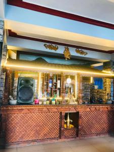 a bar with a tv on top of it at Gauri Shanker Hotel and Lodge in Dharān Bāzār
