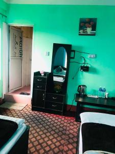 a green room with a vanity and a mirror at Gauri Shanker Hotel and Lodge in Dharān Bāzār