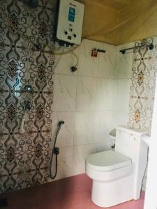 a bathroom with a white toilet and a shower at Gauri Shanker Hotel and Lodge in Dharān Bāzār +16 photos