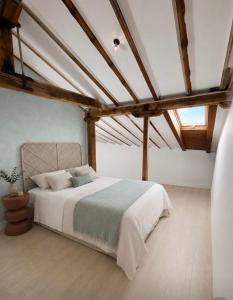 a bedroom with a bed in a room with wooden ceilings at Hotel Rural El Cedro in Lerma