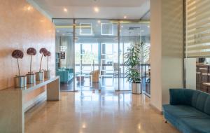 eine Lobby mit einem blauen Sofa und einigen Pflanzen in der Unterkunft Paliria Hotel in Chalkida