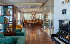 ein Wohnzimmer mit Klavier und ein Esszimmer in der Unterkunft Paliria Hotel in Chalkida