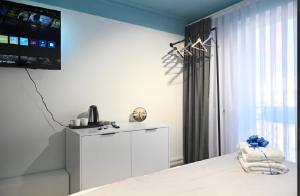 a bedroom with a bed and a tv on the wall at Juna's Hotel in Prizren
