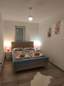 a bedroom with a bed and two lamps on the floor at Sokak Apartman in Bihać