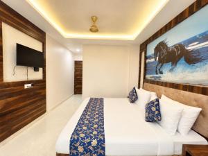 a hotel room with a bed and a painting of a horse at Hotel Rohit Rohini - New Aesthetic Hotel in Jagannath Puri with Restaurant, Parking, Free Wi-fi, Prime Location in Puri