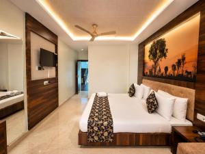 a hotel room with a bed and a tv at Hotel Rohit Rohini - New Aesthetic Hotel in Jagannath Puri with Restaurant, Parking, Free Wi-fi, Prime Location in Puri