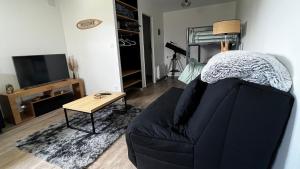 a living room with a couch and a table at Studio paisible, 30m2 in La Souterraine